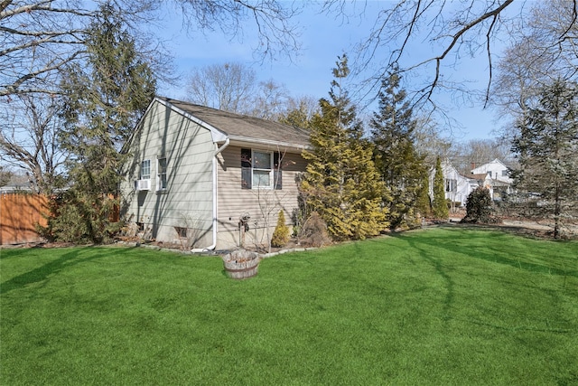 view of side of property featuring fence and a yard