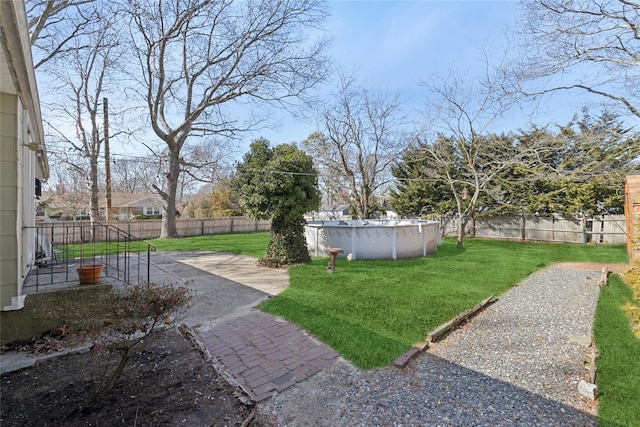 view of yard featuring a patio area, a fenced backyard, and a fenced in pool