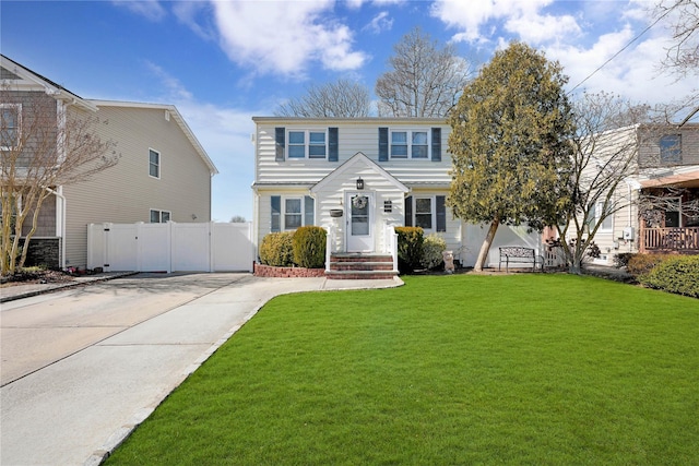 view of front facade featuring concrete driveway, fence, and a front lawn