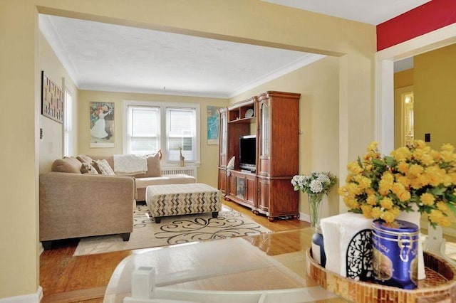 living area with crown molding, baseboards, and wood finished floors