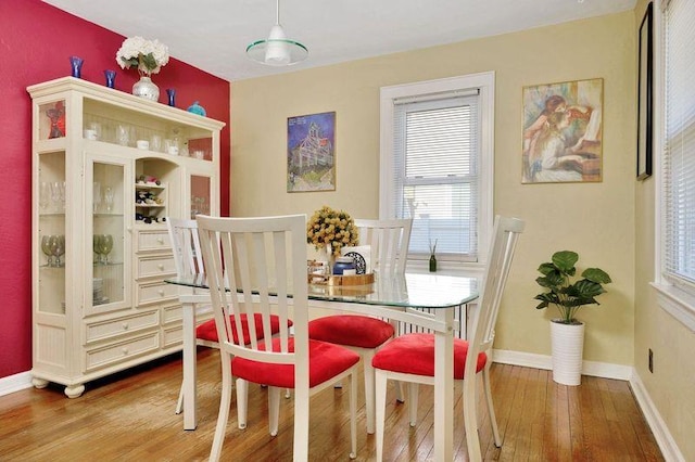 dining area with baseboards and hardwood / wood-style flooring