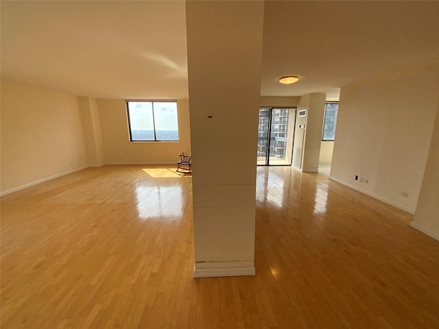 spare room featuring light wood finished floors and baseboards