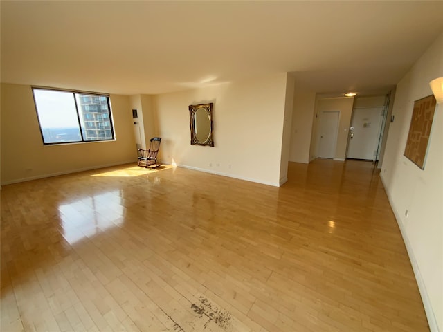 spare room with light wood-style flooring and baseboards