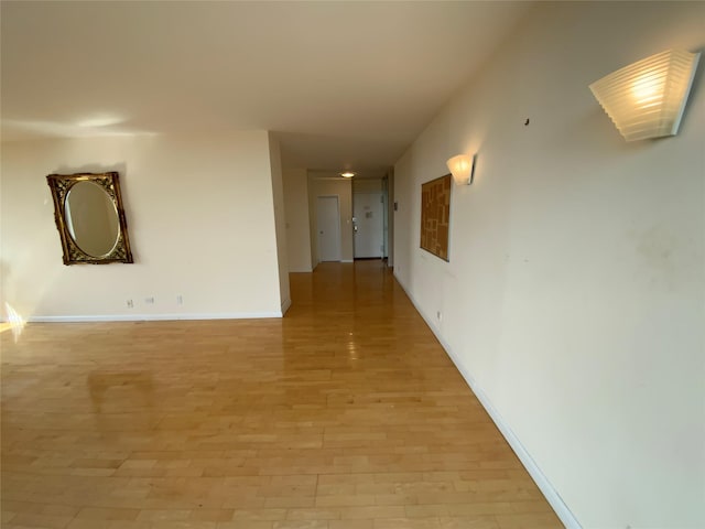 hallway with light wood finished floors and baseboards