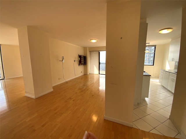 spare room featuring light wood-type flooring, a wealth of natural light, and baseboards