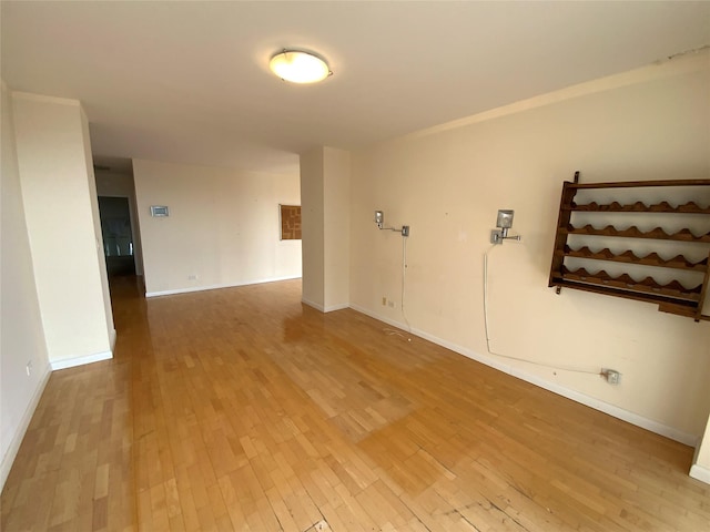 empty room featuring wood-type flooring and baseboards