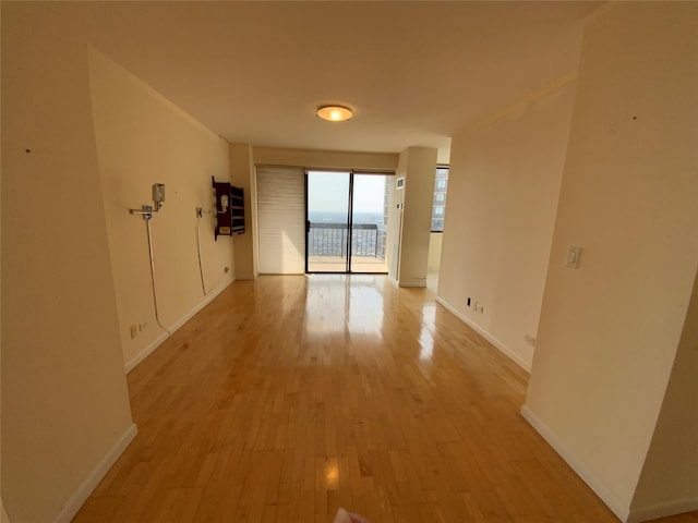 spare room with light wood-type flooring and baseboards