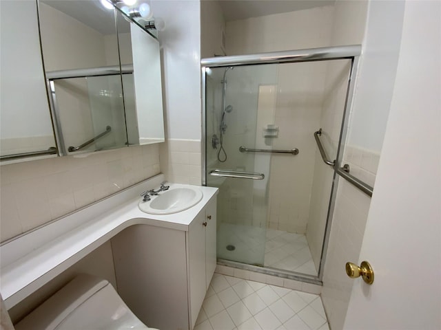 bathroom featuring tasteful backsplash, a stall shower, tile patterned flooring, and vanity