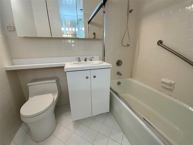 full bath featuring bathing tub / shower combination, toilet, tile patterned flooring, vanity, and tile walls