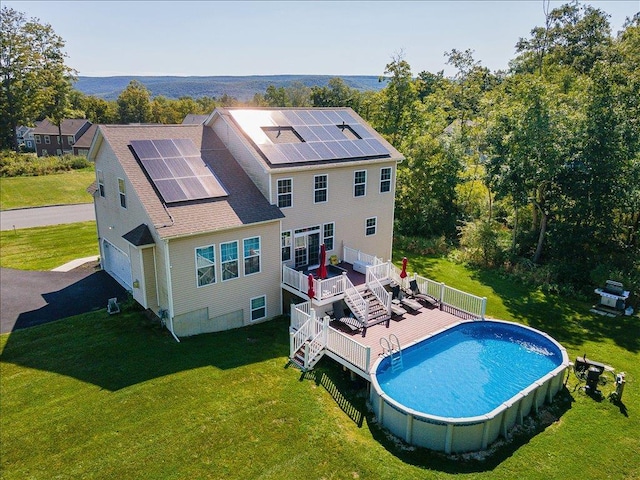 outdoor pool with stairway, a lawn, and a wooden deck