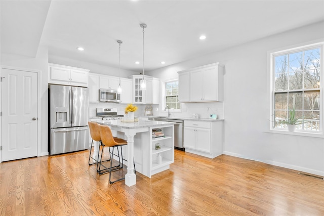 13 Hopkins Ct, Washingtonville, NY 10992 - kitchen with open shelves, light wood-type flooring, white cabinets, stainless steel appliances, and a sink