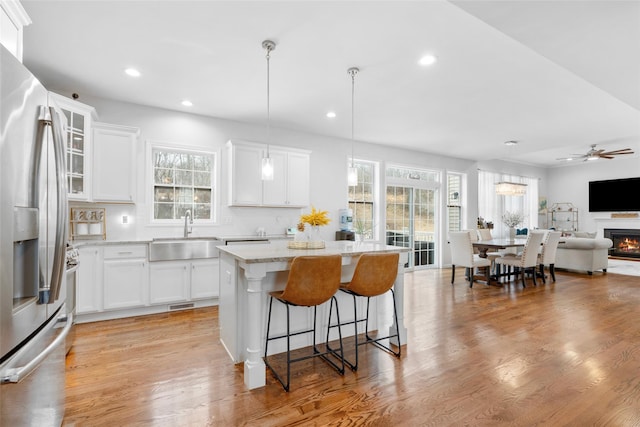 13 Hopkins Ct, Washingtonville, NY 10992 - kitchen featuring light wood-type flooring, a kitchen island, a sink, stainless steel fridge, and open floor plan