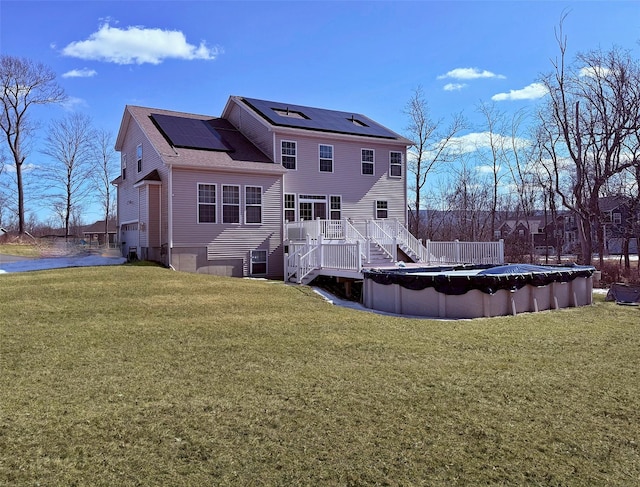 13 Hopkins Ct, Washingtonville, NY 10992 - rear view of property featuring a lawn, a deck, a covered pool, roof mounted solar panels, and a shingled roof