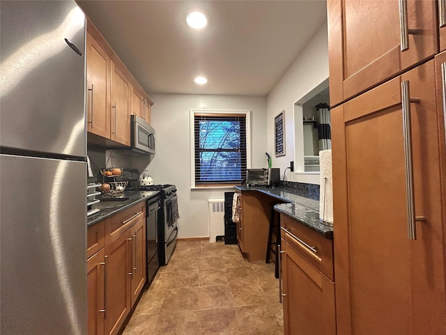 kitchen with recessed lighting, stainless steel appliances, baseboards, radiator, and dark stone counters