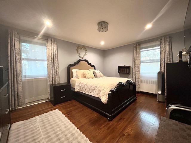 bedroom with dark wood-style flooring and radiator