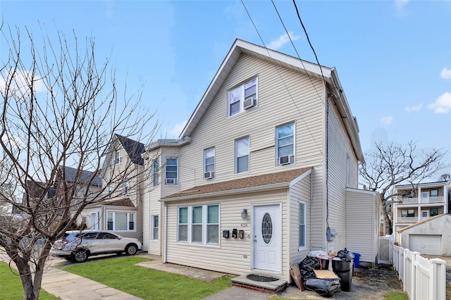 townhome / multi-family property with fence and a front yard