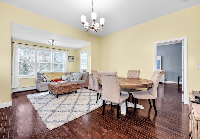 dining space featuring a chandelier, baseboards, dark wood finished floors, and baseboard heating