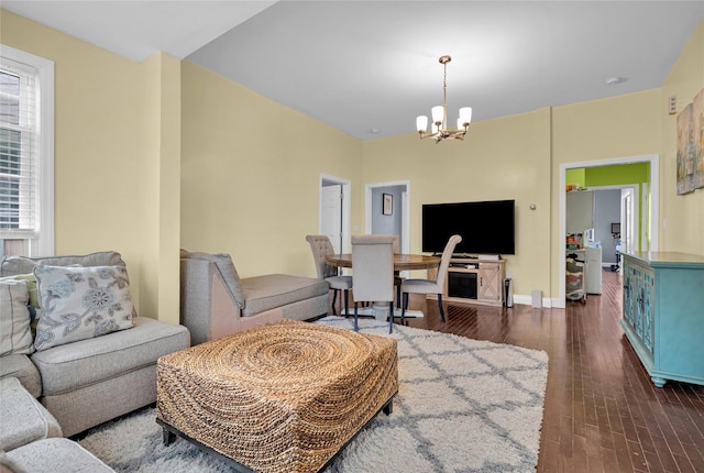 living room with a notable chandelier, baseboards, and dark wood-style flooring