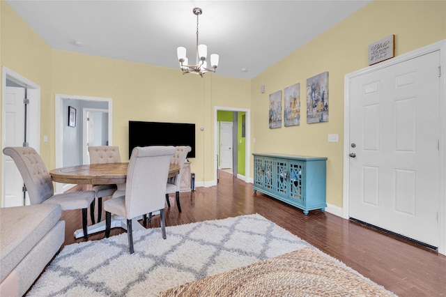 dining space featuring baseboards, wood finished floors, and an inviting chandelier