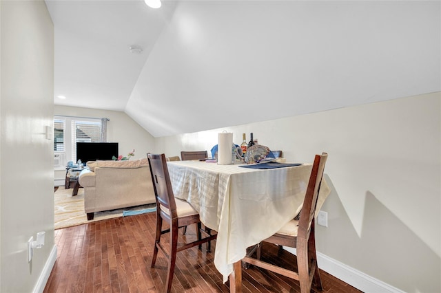 dining room with lofted ceiling, wood-type flooring, and baseboards