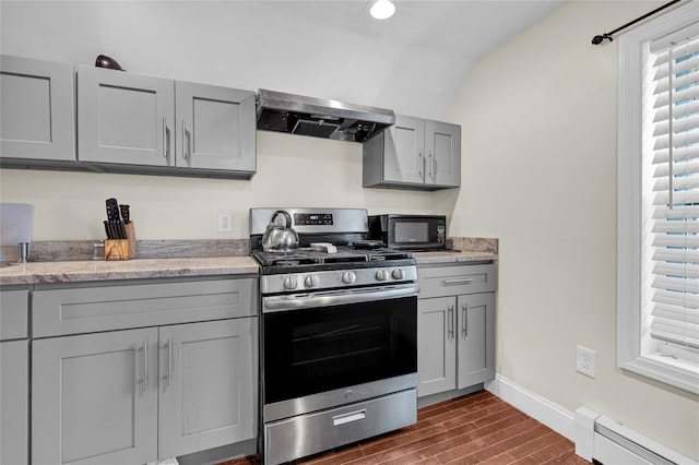 kitchen with a baseboard radiator, gray cabinets, stainless steel range with gas stovetop, and exhaust hood