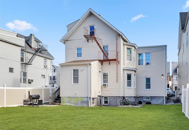 rear view of property featuring a yard and fence