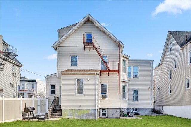 back of property featuring cooling unit, entry steps, a yard, and fence