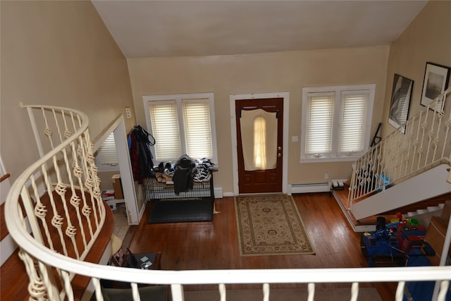 entryway featuring stairway, baseboard heating, and wood finished floors