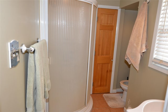 full bathroom featuring a stall shower, toilet, and tile patterned floors