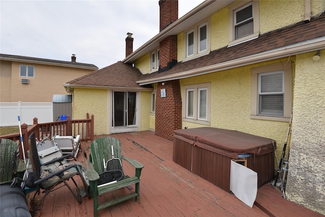 wooden terrace with fence and a hot tub