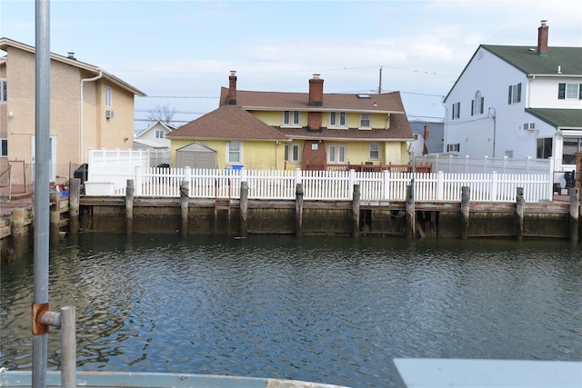 exterior space with fence private yard, a water view, and a residential view