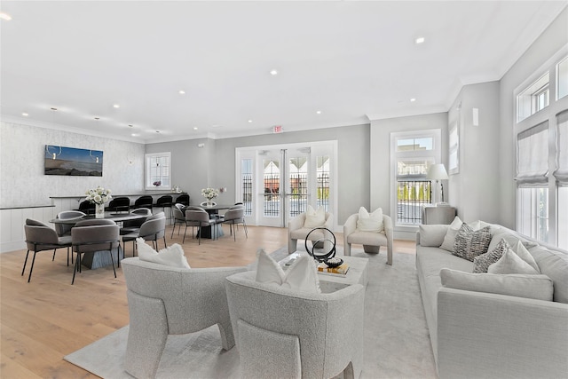 living room featuring plenty of natural light, light wood finished floors, and ornamental molding