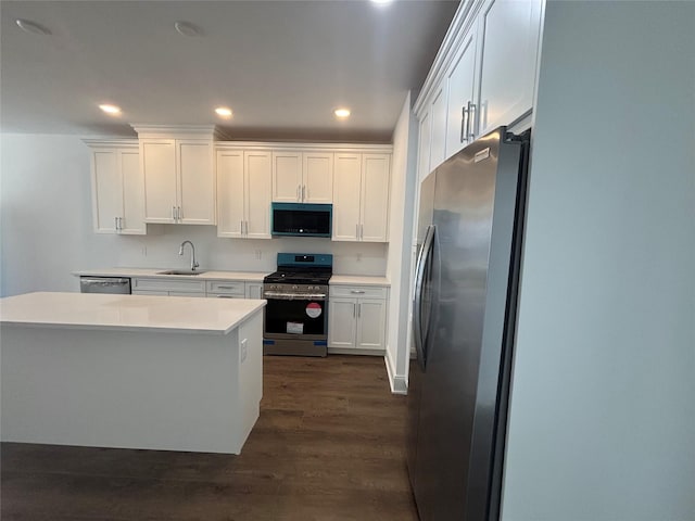 kitchen featuring dark wood-style flooring, a sink, stainless steel appliances, light countertops, and white cabinetry