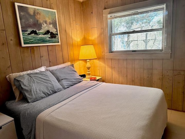 bedroom featuring wood walls