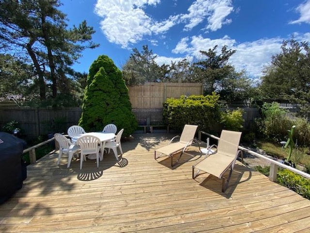 wooden terrace with a fenced backyard