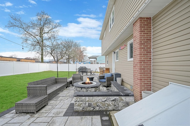 view of patio with a fenced backyard and an outdoor living space with a fire pit