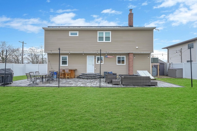 back of property with a chimney, a lawn, a patio area, fence private yard, and an outdoor living space