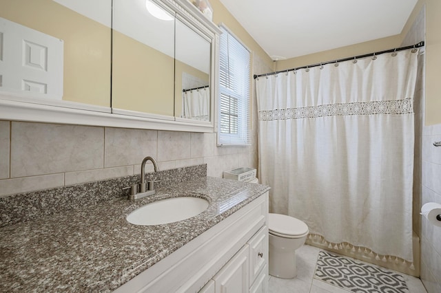 bathroom with toilet, tile patterned floors, vanity, tile walls, and shower / tub combo with curtain