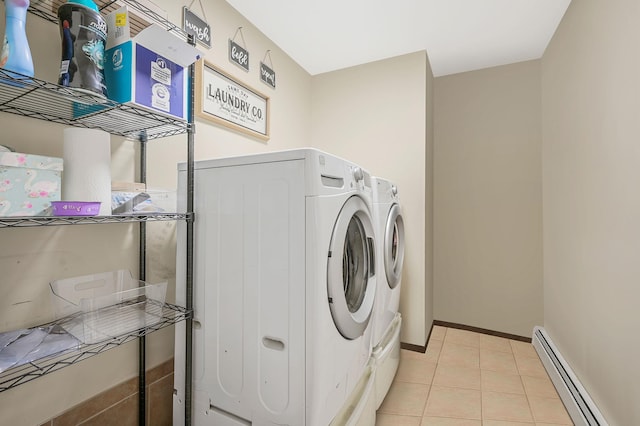 laundry area with light tile patterned floors, a baseboard heating unit, laundry area, baseboards, and washing machine and clothes dryer