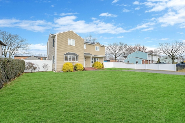 view of front of home featuring a front yard and a fenced backyard