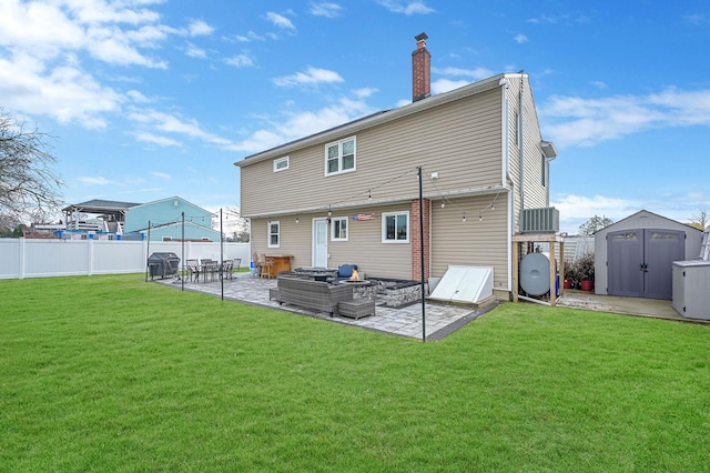 back of property featuring a yard, a storage shed, an outdoor fire pit, a patio area, and an outdoor structure