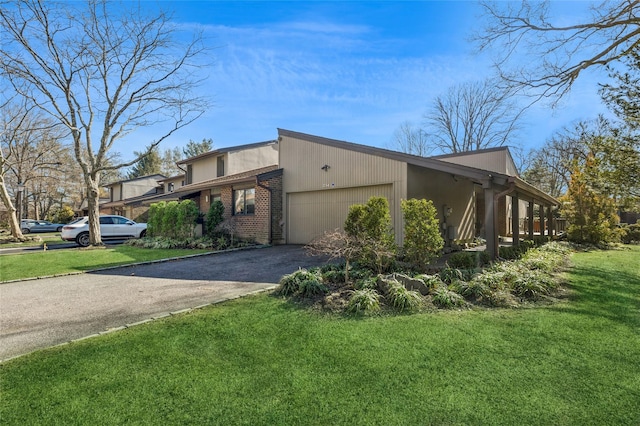 view of property exterior featuring brick siding, a lawn, driveway, and a garage