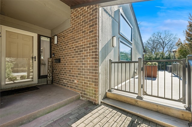 entrance to property featuring brick siding