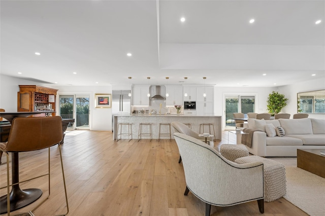 living area featuring a wealth of natural light, light wood-style flooring, and recessed lighting