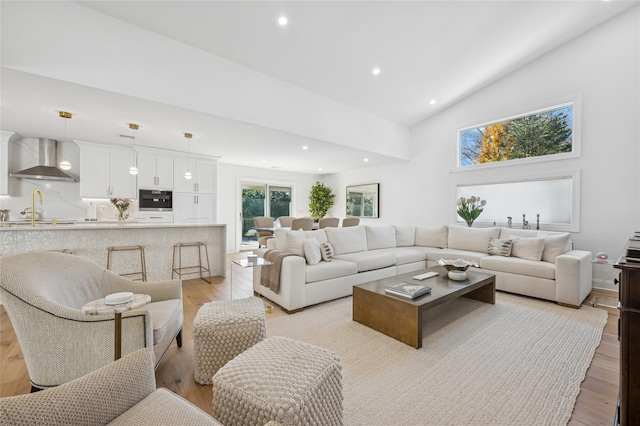 living room featuring light wood finished floors, recessed lighting, and high vaulted ceiling