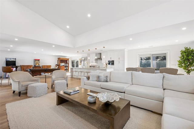 living area featuring recessed lighting, high vaulted ceiling, and light wood-style floors