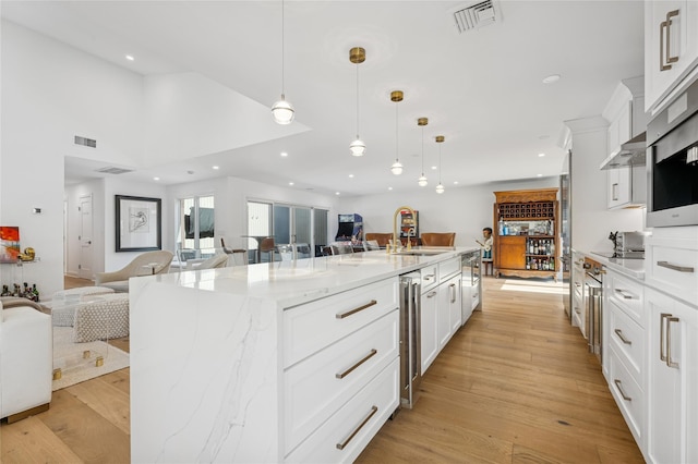 kitchen with light wood-style floors, visible vents, and open floor plan