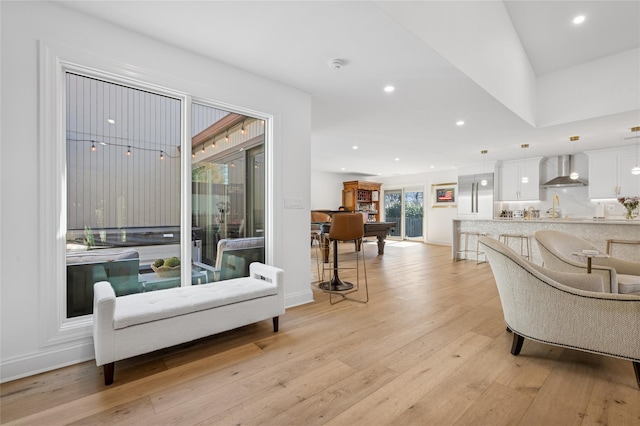 living area featuring recessed lighting, baseboards, and light wood-style flooring