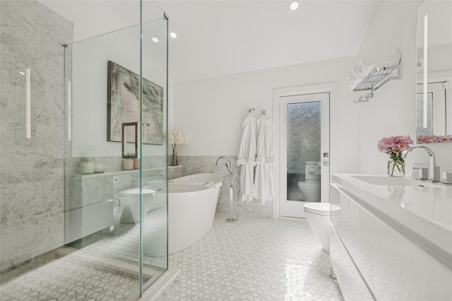 full bath with tile walls, toilet, a stall shower, a freestanding tub, and vanity