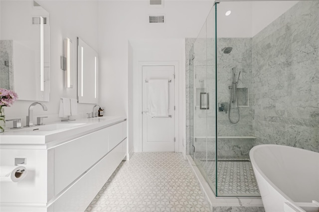 full bath featuring visible vents, a stall shower, a freestanding bath, and vanity